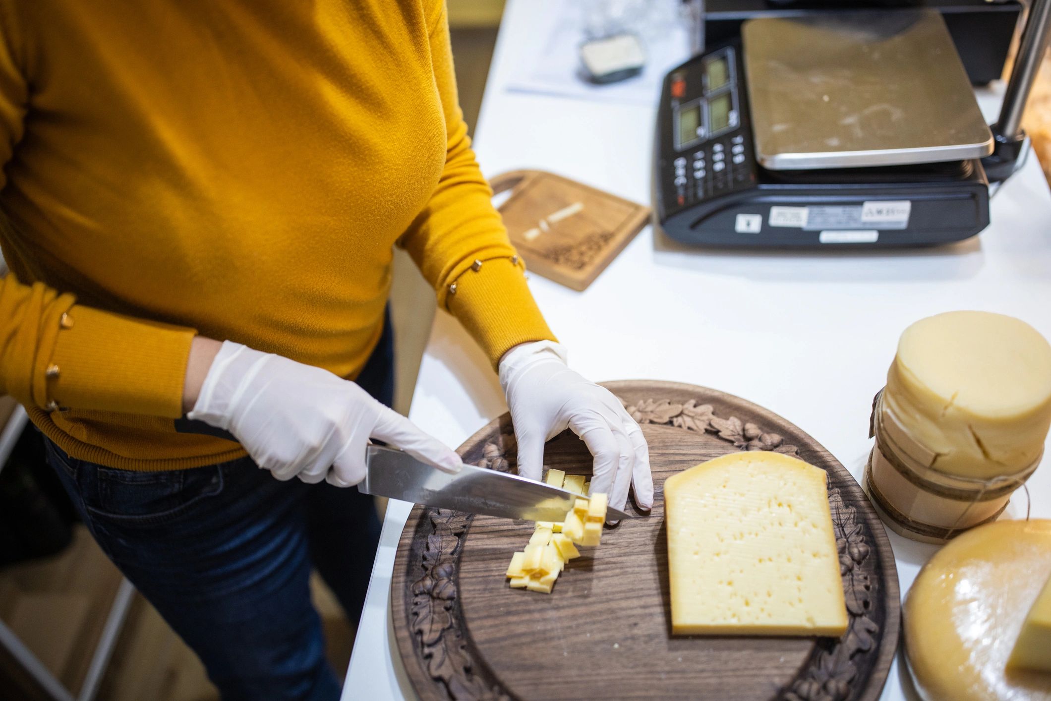 Person cutting cheese into pieces