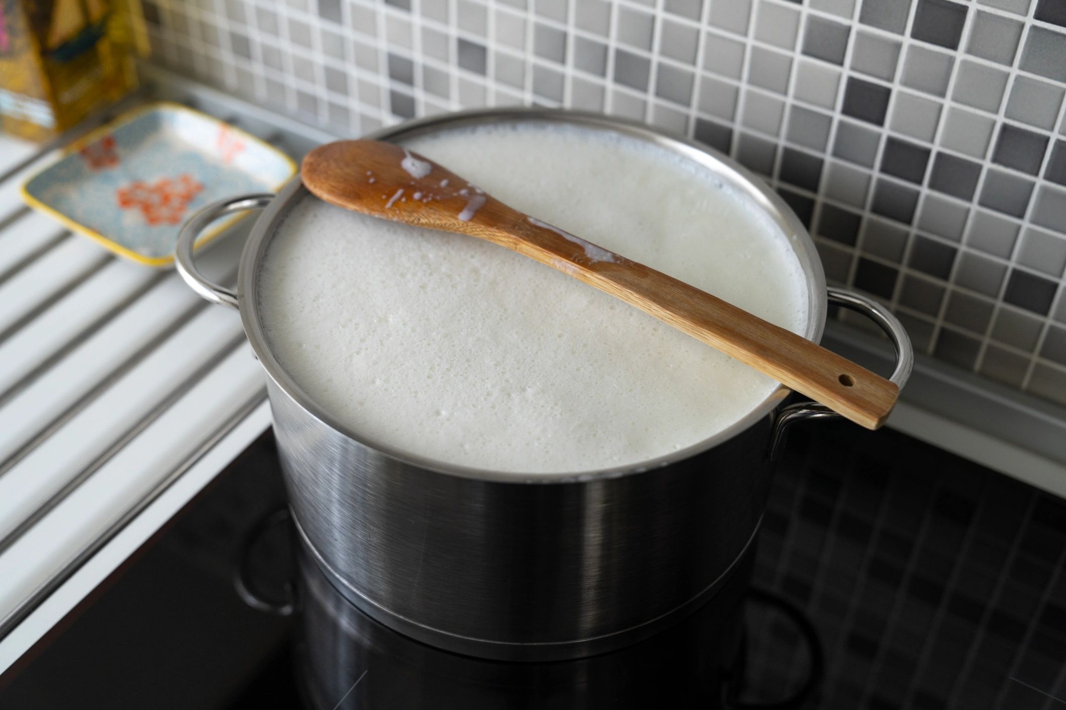 Heating milk in a pot with a wooden spoon for home cheesemaking
