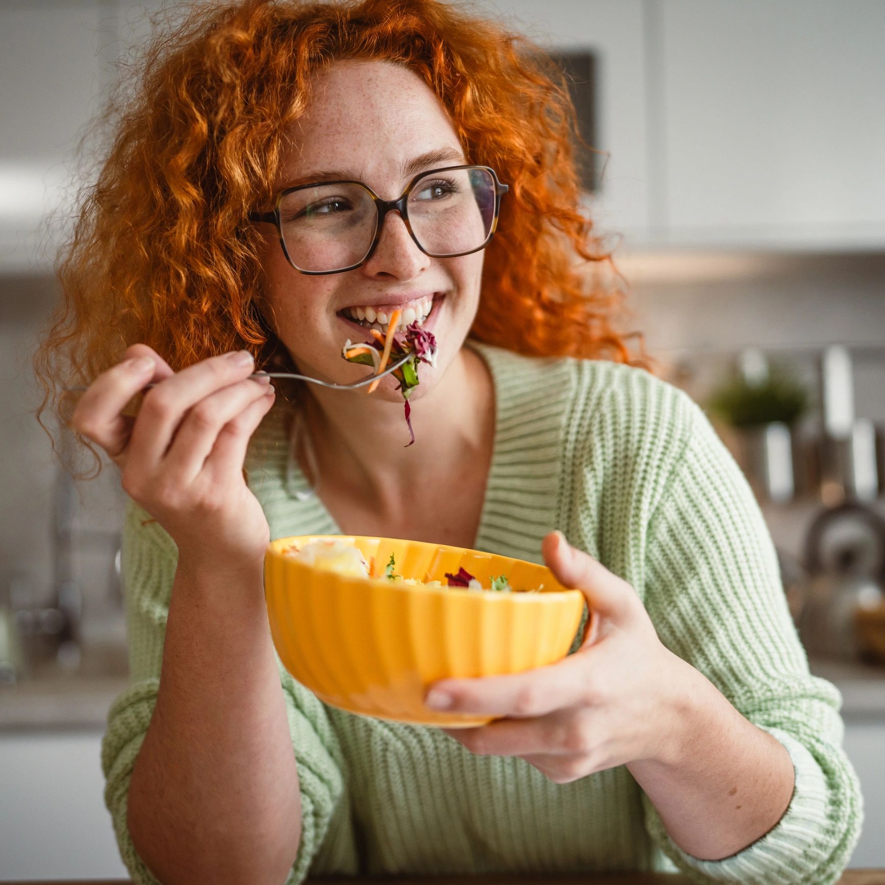 Person enjoying a meal in a kitchen