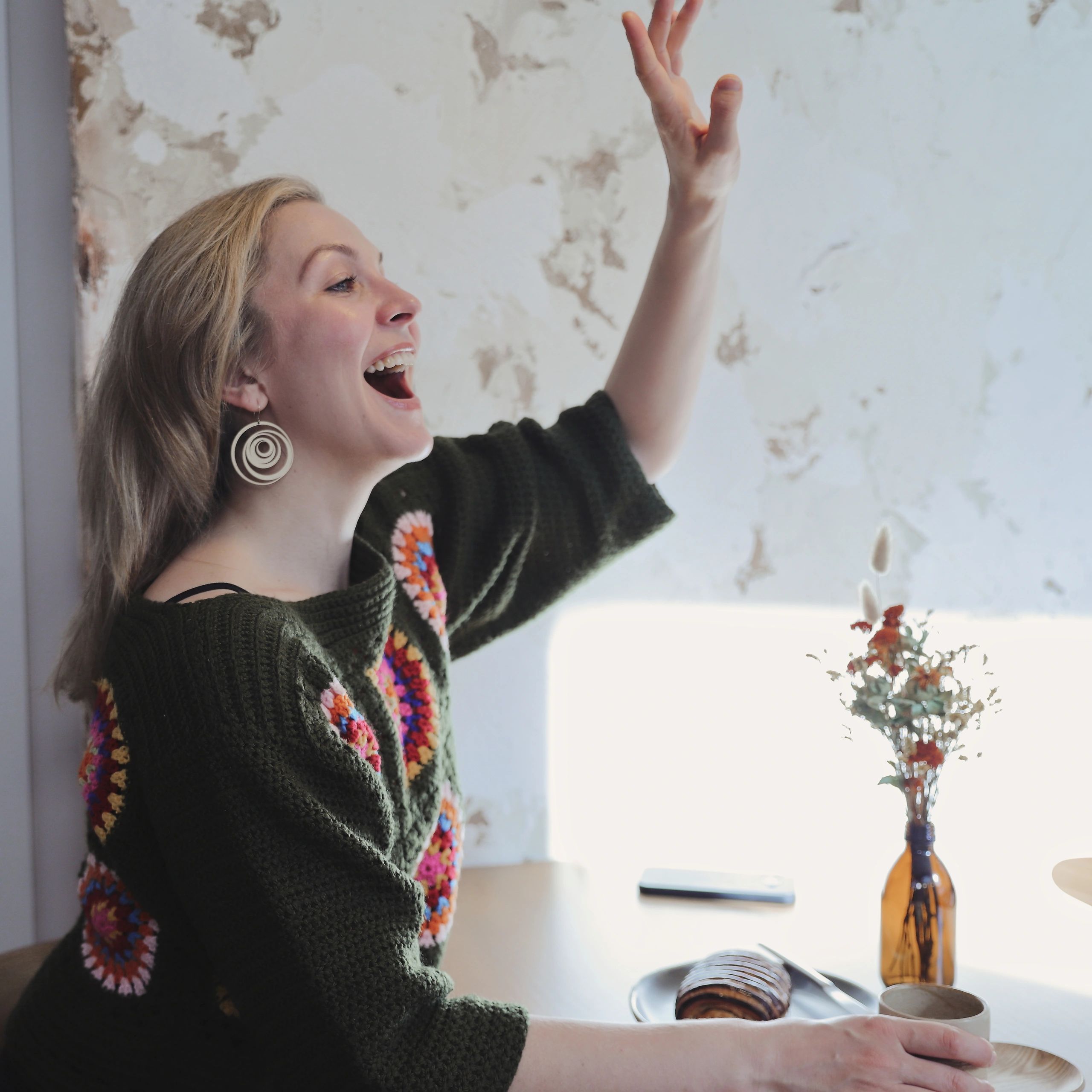Smiling person in a cafe with coffee cup